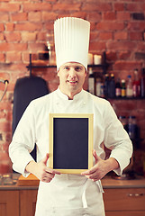 Image showing happy male chef with blank menu board in kitchen