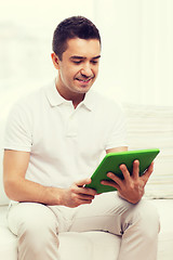 Image showing smiling man working with tablet pc at home