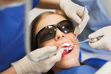 Image showing female dentists treating patient girl teeth