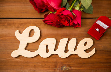 Image showing close up of diamond ring, red roses and word love