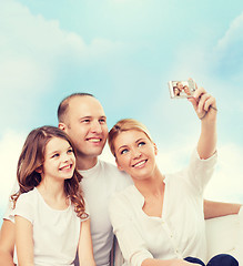 Image showing happy family with camera at home