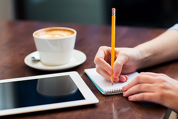 Image showing close up of woman writing to notebook with pencil