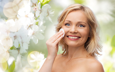 Image showing happy woman cleaning face with cotton pad