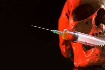 Image showing Skull and syringe of yellowish liquid. concept drugs