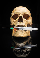 Image showing Skull and syringe of yellowish liquid. concept drugs