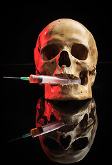 Image showing Skull and syringe of yellowish liquid. concept drugs