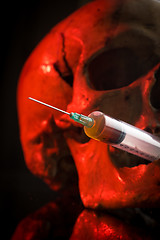 Image showing Skull and syringe of yellowish liquid. concept drugs