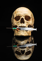 Image showing Skull and syringe of yellowish liquid. concept drugs