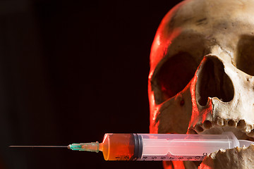 Image showing Skull and syringe of yellowish liquid. concept drugs