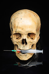 Image showing Skull and syringe of yellowish liquid. concept drugs