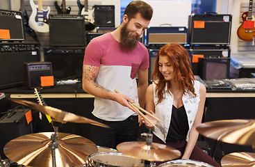 Image showing man and woman with drum kit at music store