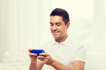 Image showing happy man with smartphone at home