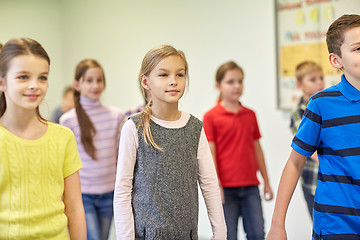 Image showing group of smiling school kids walking in corridor