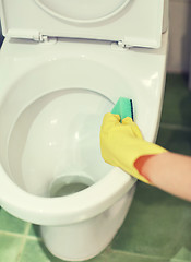 Image showing close up of hand with detergent cleaning toilet