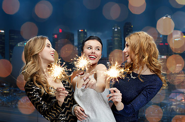 Image showing happy young women with sparklers over night city