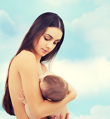 Image showing happy mother feeding her adorable baby