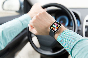 Image showing close up of man with app on smartwatch driving car