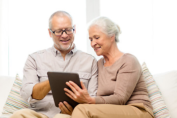 Image showing happy senior couple with tablet pc at home