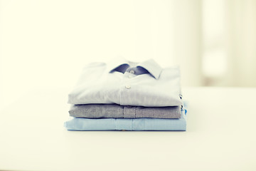 Image showing close up of ironed and folded shirts on table