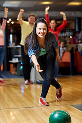 Image showing happy young woman throwing ball in bowling club