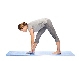 Image showing woman making yoga intense stretch pose on mat