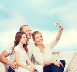 Image showing happy family with camera at home