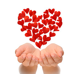 Image showing Hearts in heart shape flying over cupped hands of young woman