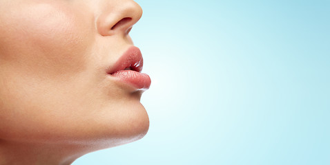 Image showing close up of young woman lips over blue