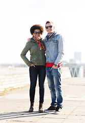 Image showing happy teenage friends in shades hugging outdoors