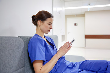 Image showing female doctor or nurse with smartphone at hospital