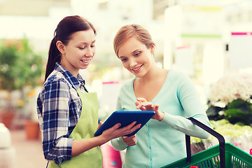 Image showing happy women with tablet pc in greenhouse