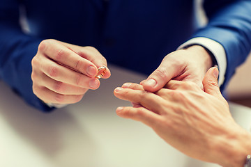 Image showing close up of male gay couple hands and wedding ring