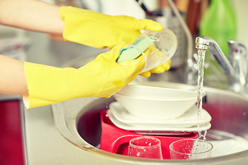 Image showing close up of woman hands washing dishes in kitchen