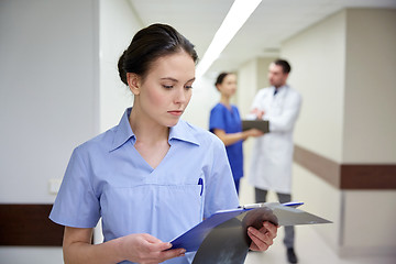 Image showing female doctor or nurse with clipboard at hospital