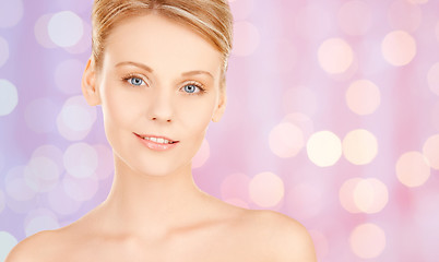 Image showing lovely woman face over pink lights background