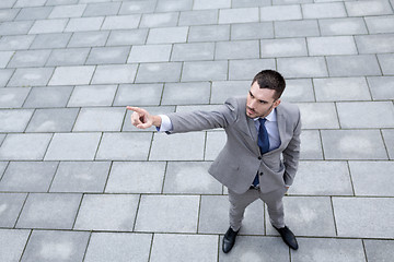 Image showing young smiling businessman outdoors from top