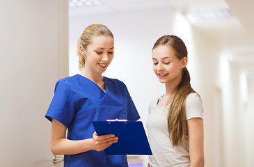 Image showing doctor or nurse with clipboard and girl patient