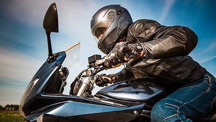 Image showing Biker racing on the road