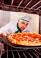 Image showing Chef cooking pizza in the oven.