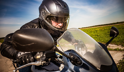 Image showing Biker racing on the road