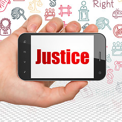 Image showing Law concept: Hand Holding Smartphone with Justice on display