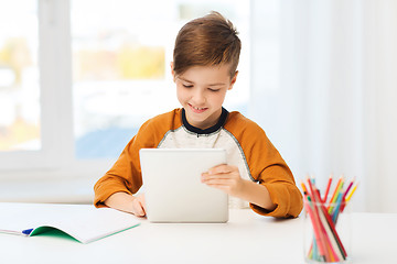 Image showing smiling boy with tablet pc and notebook at home