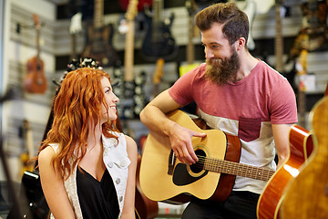 Image showing couple of musicians with guitar at music store