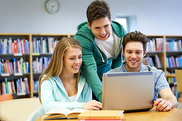 Image showing happy students with laptop in library