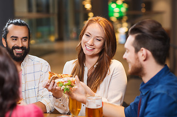 Image showing friends eating pizza with beer at restaurant