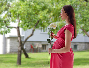 Image showing happy pregnant woman with rose flower