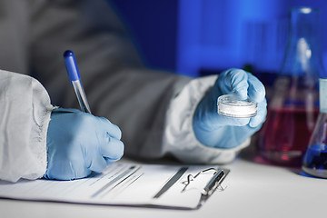 Image showing close up of scientist writing test results in lab