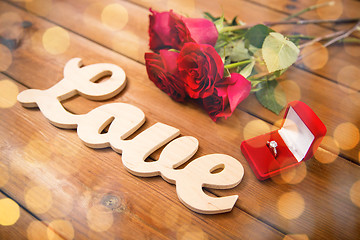 Image showing close up of diamond ring, red roses and word love