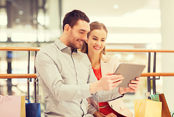 Image showing couple with tablet pc and shopping bags in mall