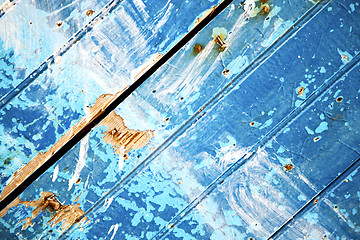 Image showing stripped paint in the blue  and rusty nail